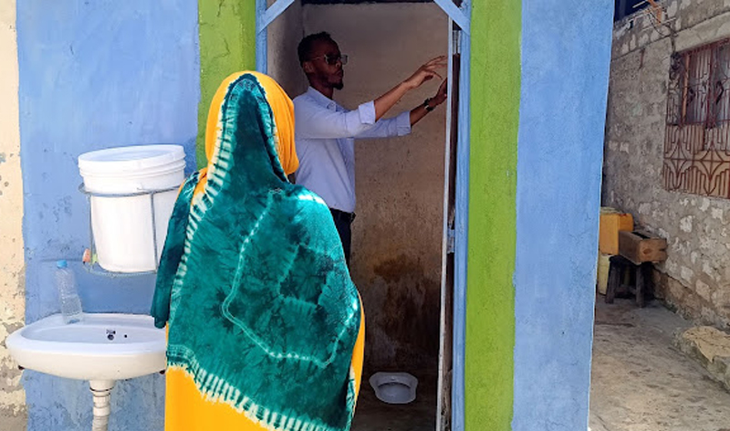 Mowasco managing director Abdirahim Farah inspects Mwanaisha Nuru's rehabilitated toilet